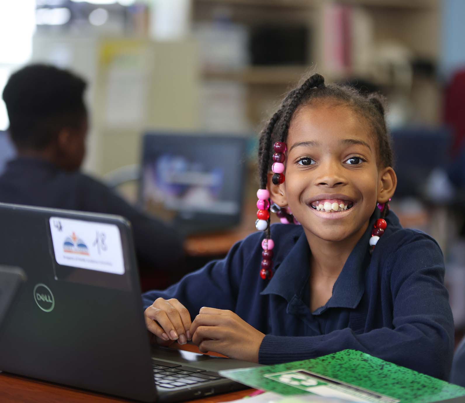 Noble Academy Euclid student wearing headphones uses a laptop in class